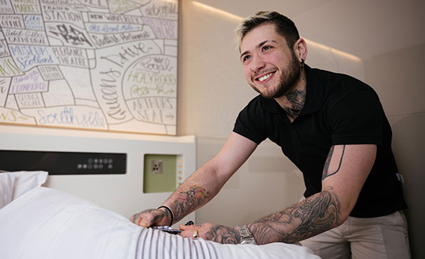 smiling-colleague-making-the-bed