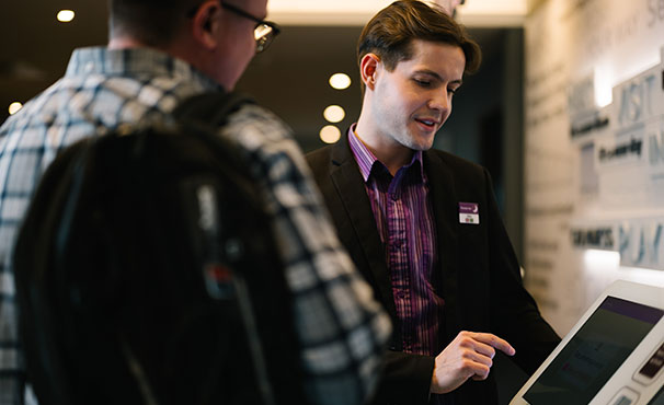 reception-staff-showing-a-guest-how-to-check-in